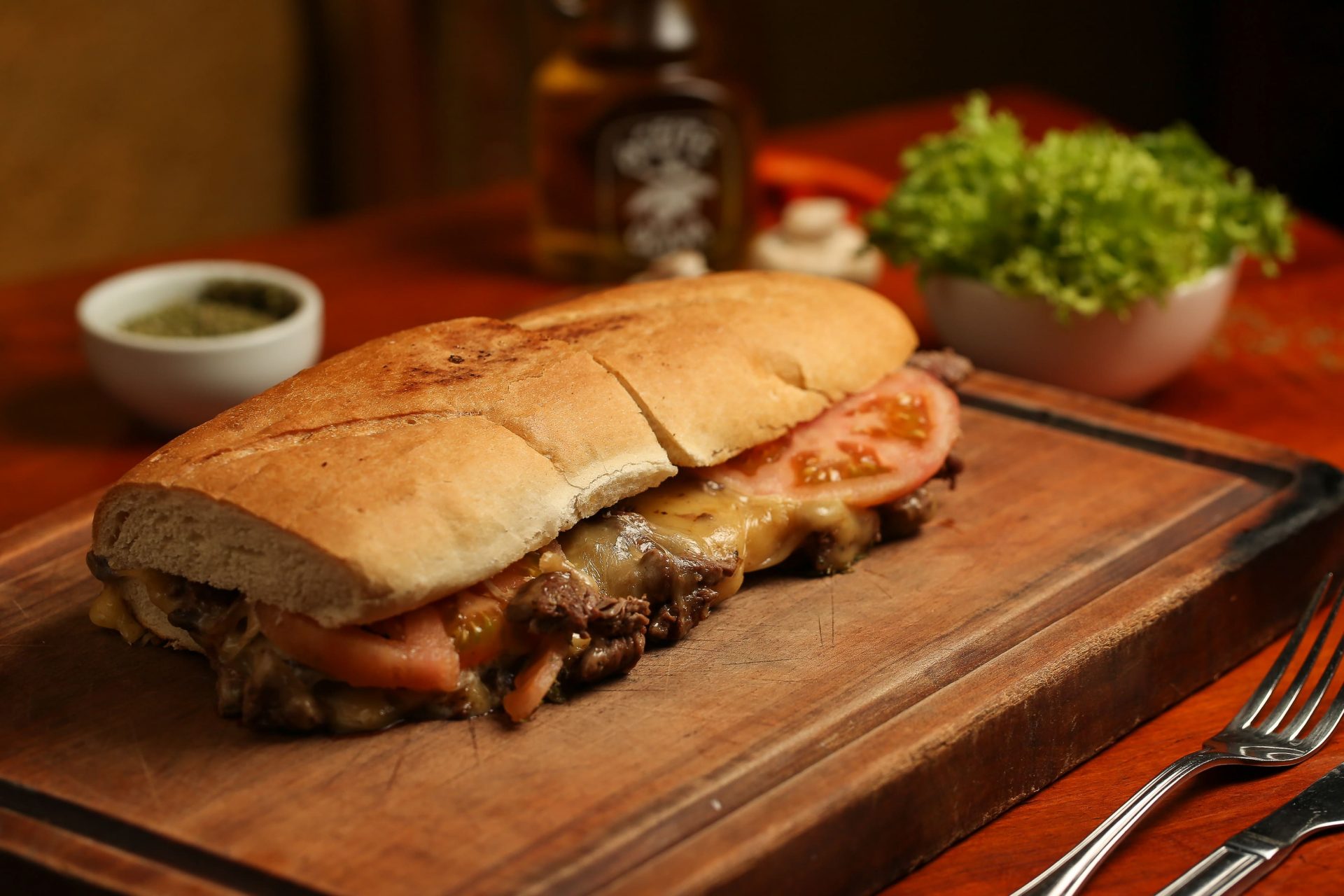 Sándwich de carne mechada con queso fundido y tomate