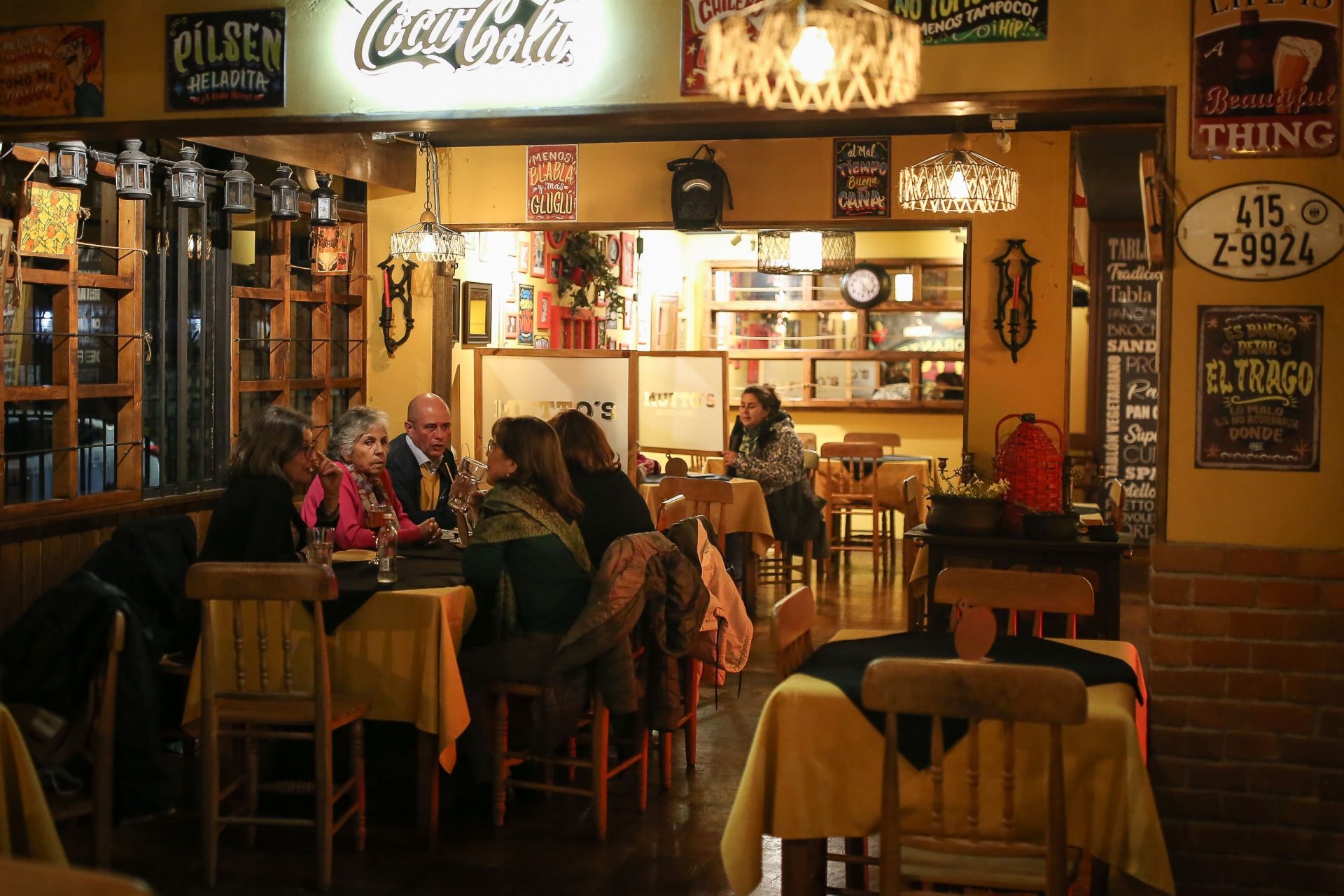 Mesa de amigos y familias compartiendo pizza en Mutto's