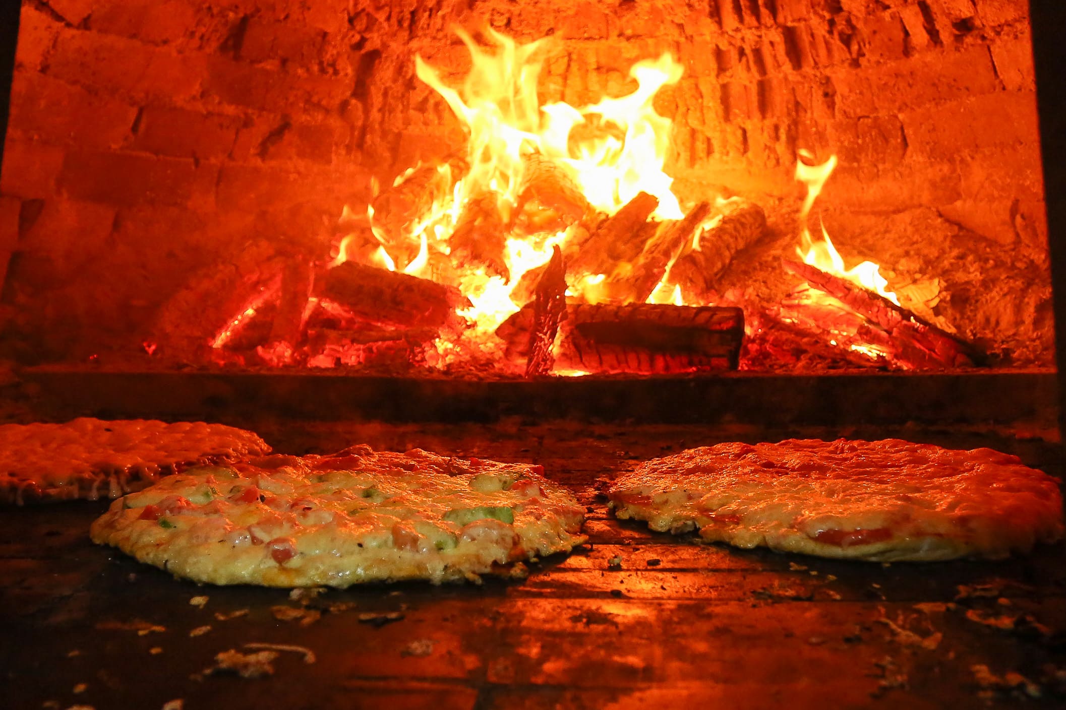 Pizzas horneándose a 450°C sobre piedra refractaria y brasa nativa