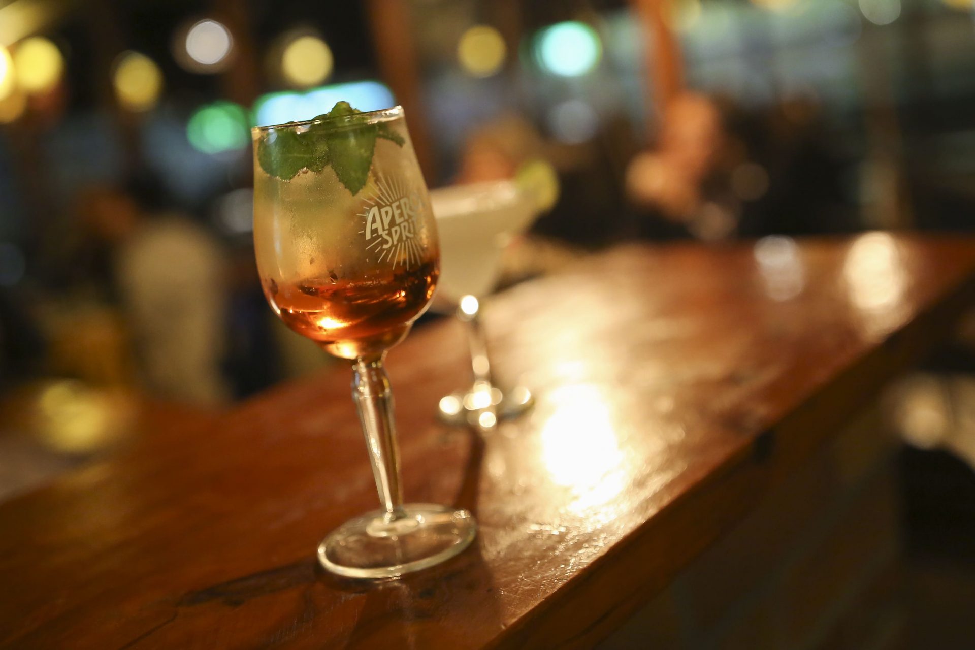 Copa de Aperol Spritz con menta en la barra
