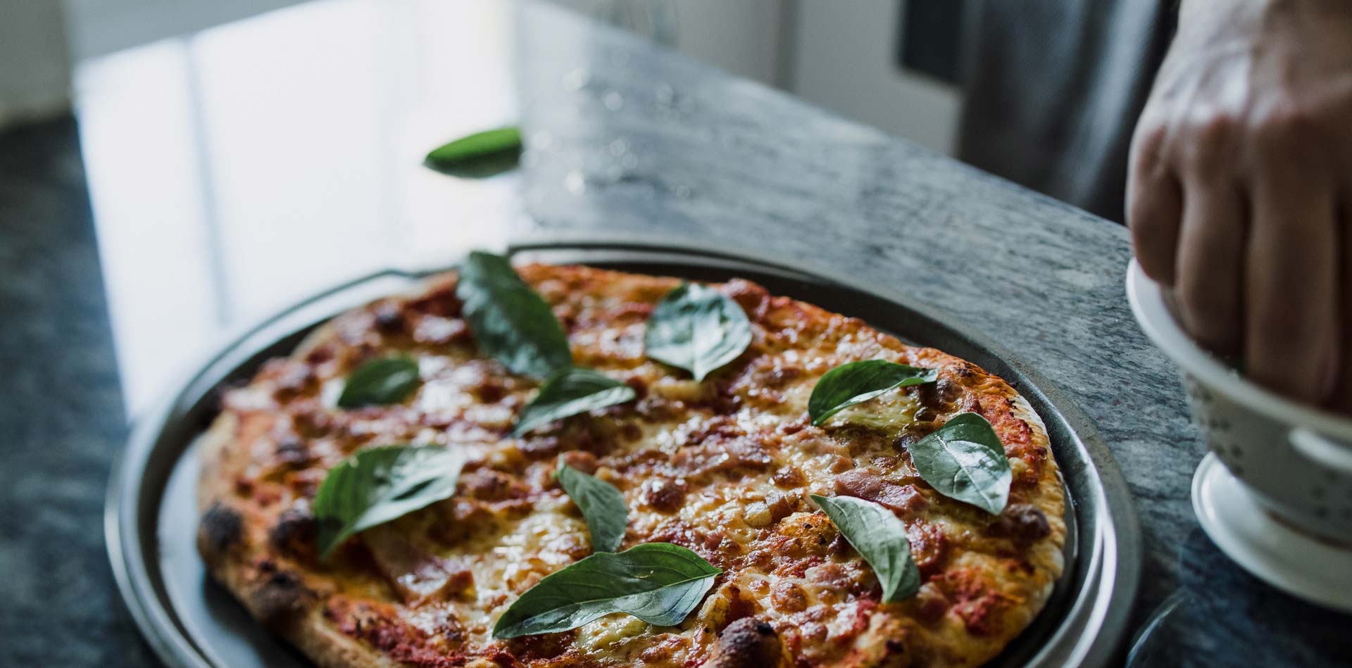 Pizza al horno de leña Mutto's con albahaca fresca